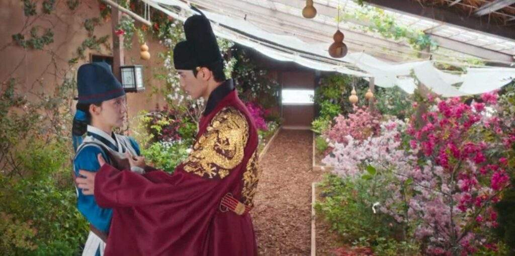 Ji-Yeong and Lee Heon in the greenhouse looking at each other in Bon Appetit Episode 5