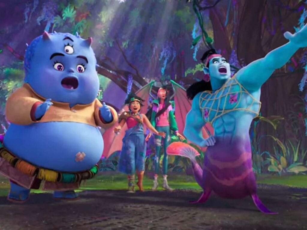 Bungi, a round blue tiyanak, and Prince Mermahn, a muscular blue kataw, react in surprise as Jo and Raissa stand behind them in a vibrant forest filled with towering trees, glowing plants, and oversized mushrooms.