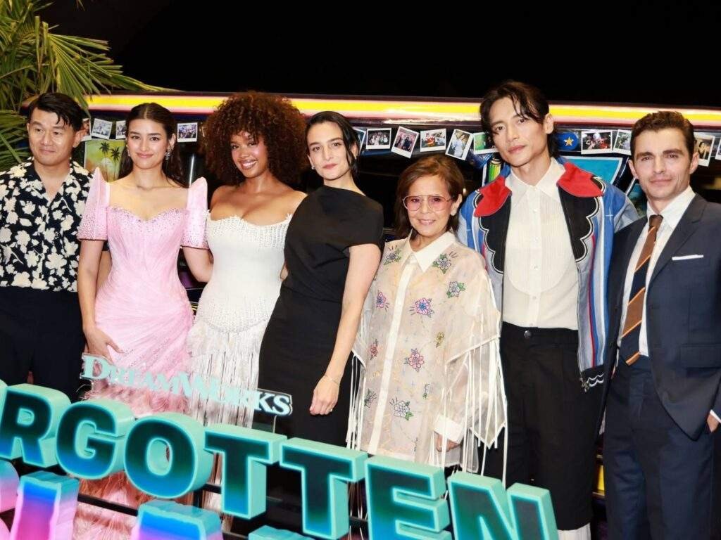 The Forgotten Island cast and filmmakers pose together for a group photo in front of a brightly decorated jeepney and the film's logo during a promotional event.